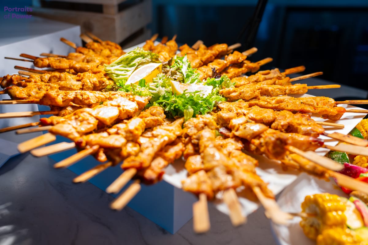 Chicken skewers arranged around a centrepiece of salad and lemon at a catered corporate event